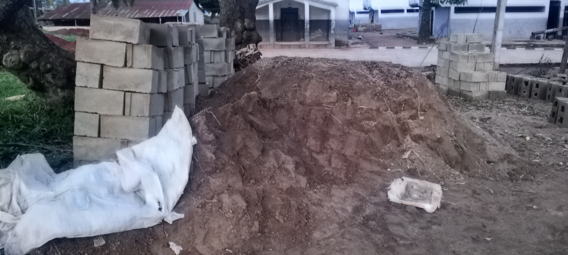 Foundation excavation at the SHSAOBA building site — Excavated earth beside moulded blocks stacked on site