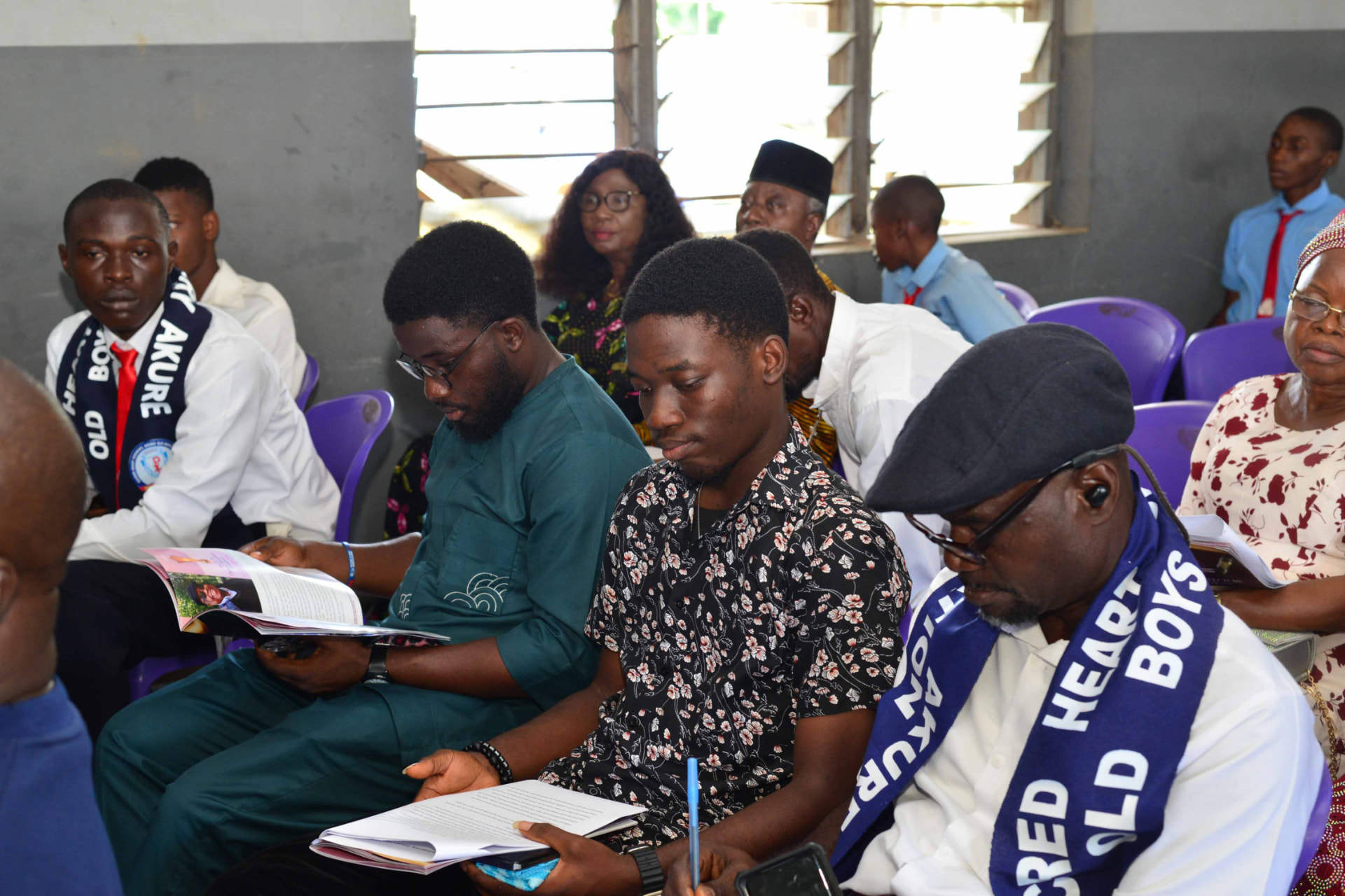 SHSAOBA members seated with event programmes during an Association gathering